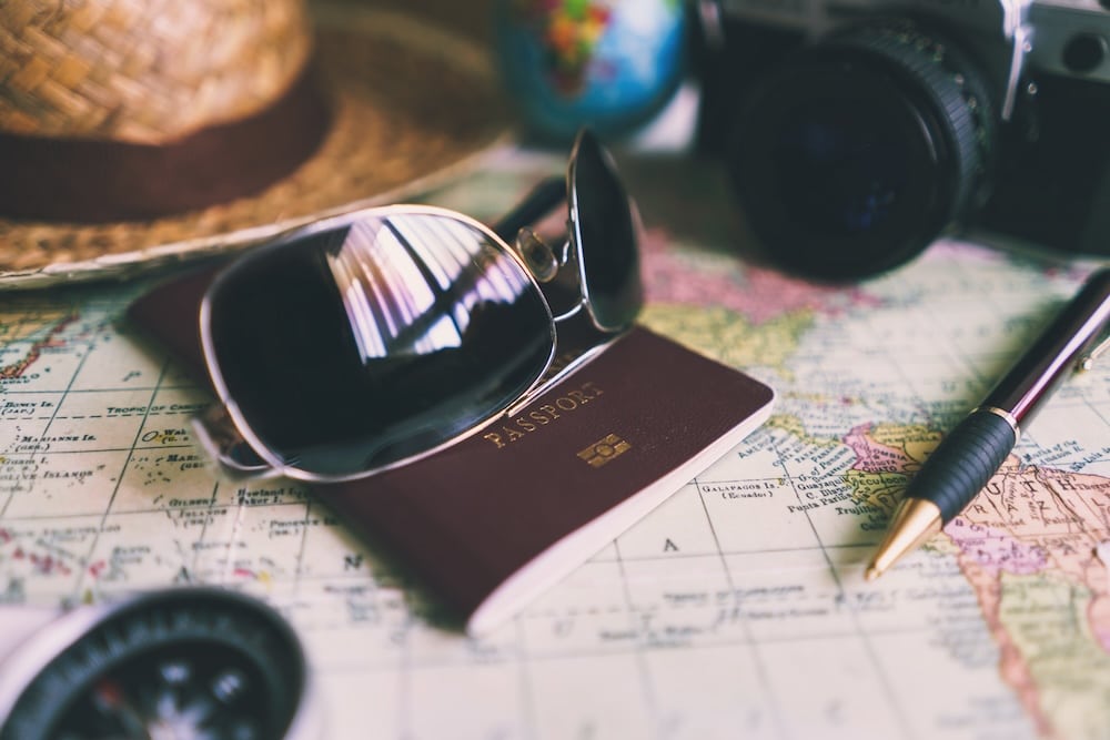 semesterlagen, bild på solglasögon, pass, hatt på karta