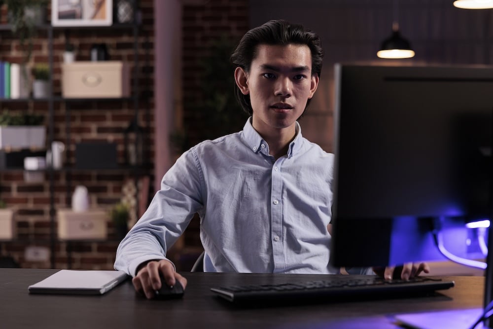 Man sitting in front of computer, wondering about starting a shelf corporation.