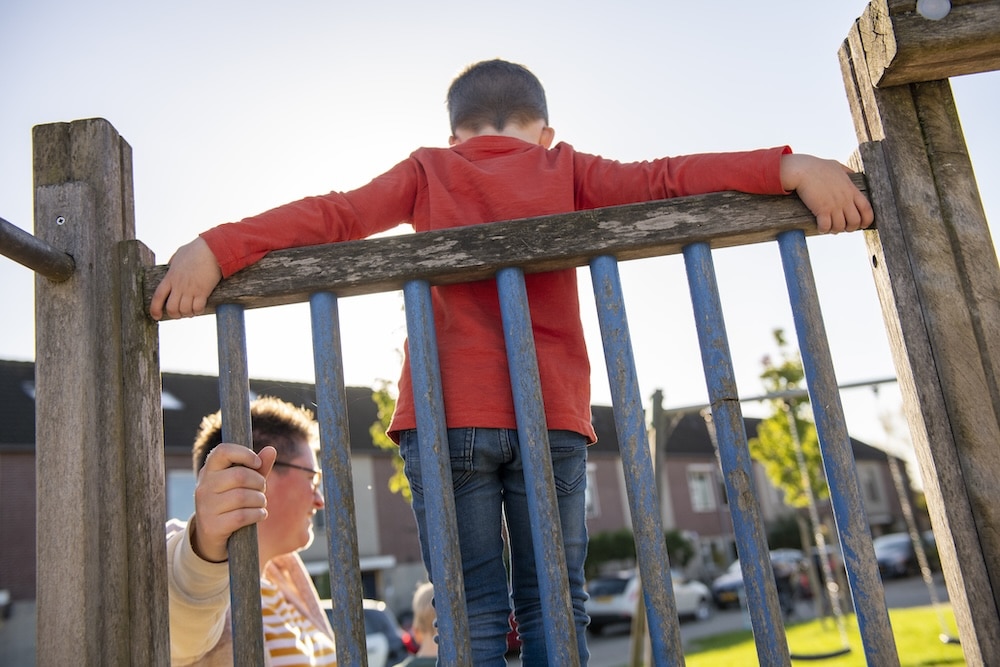 förälder med barn i lekpark i artikel om umgängessabotage.