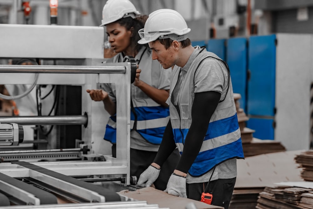 Two employees in a factory in article about the responsibilities of an employee